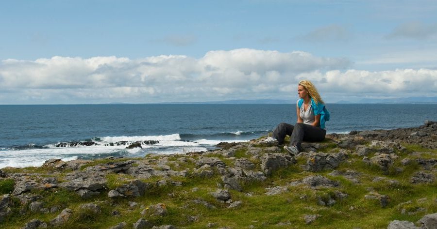 woman sitting by ocean on the Burren Way Ireland