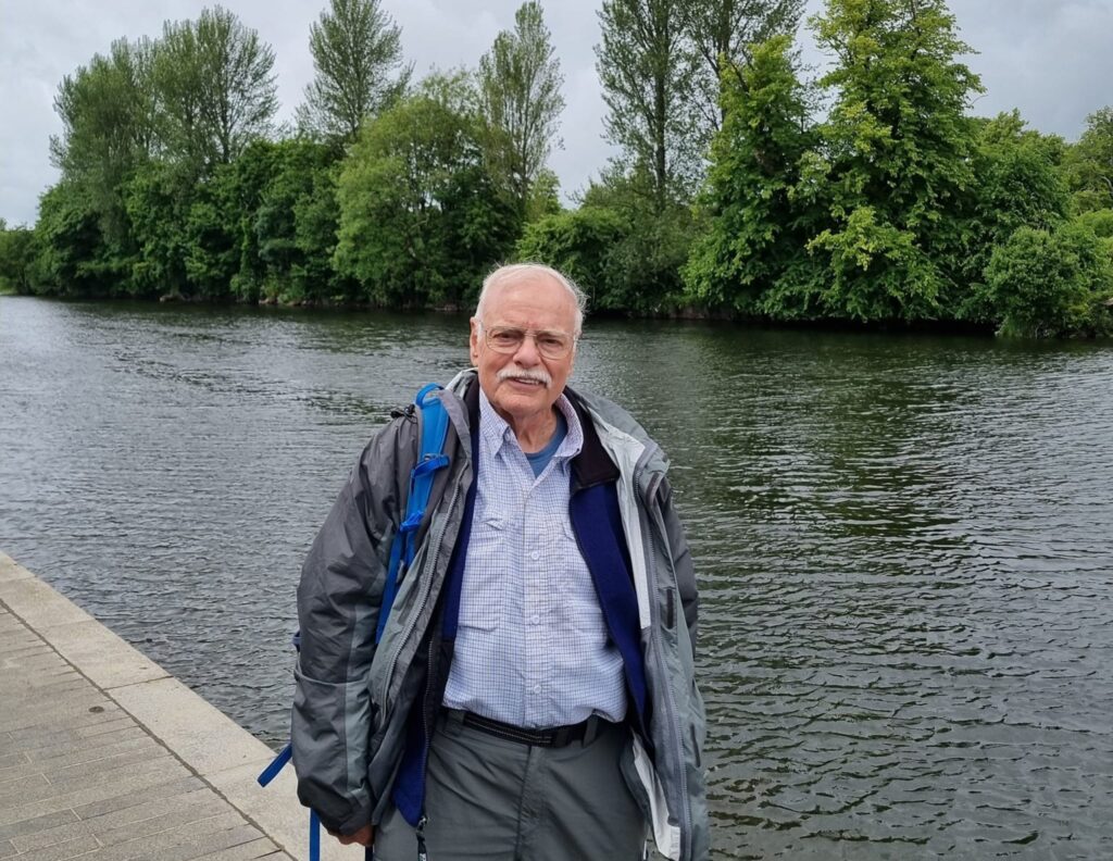 man standing by water while hiking across Ireland