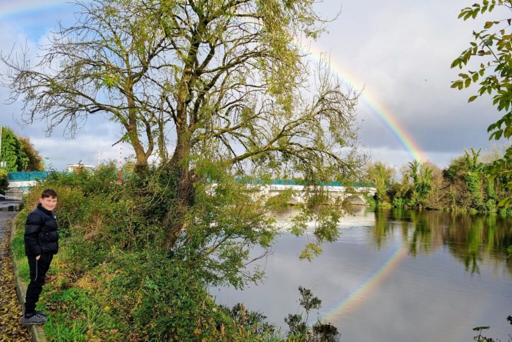 boy smiling at rainbow over Royal Canal in Ireland